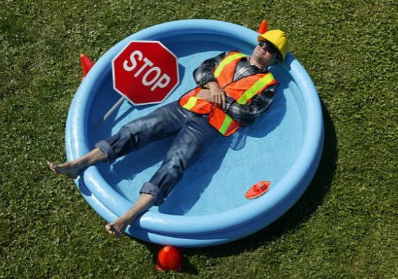 Construction Worker Lying Down In A Swimming Pool